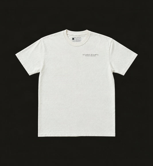 An off-white crewneck t-shirt with 'Silent Giants on top of He speaks through you.' printed in black on the left chest, laid flat on a charcoal background.
